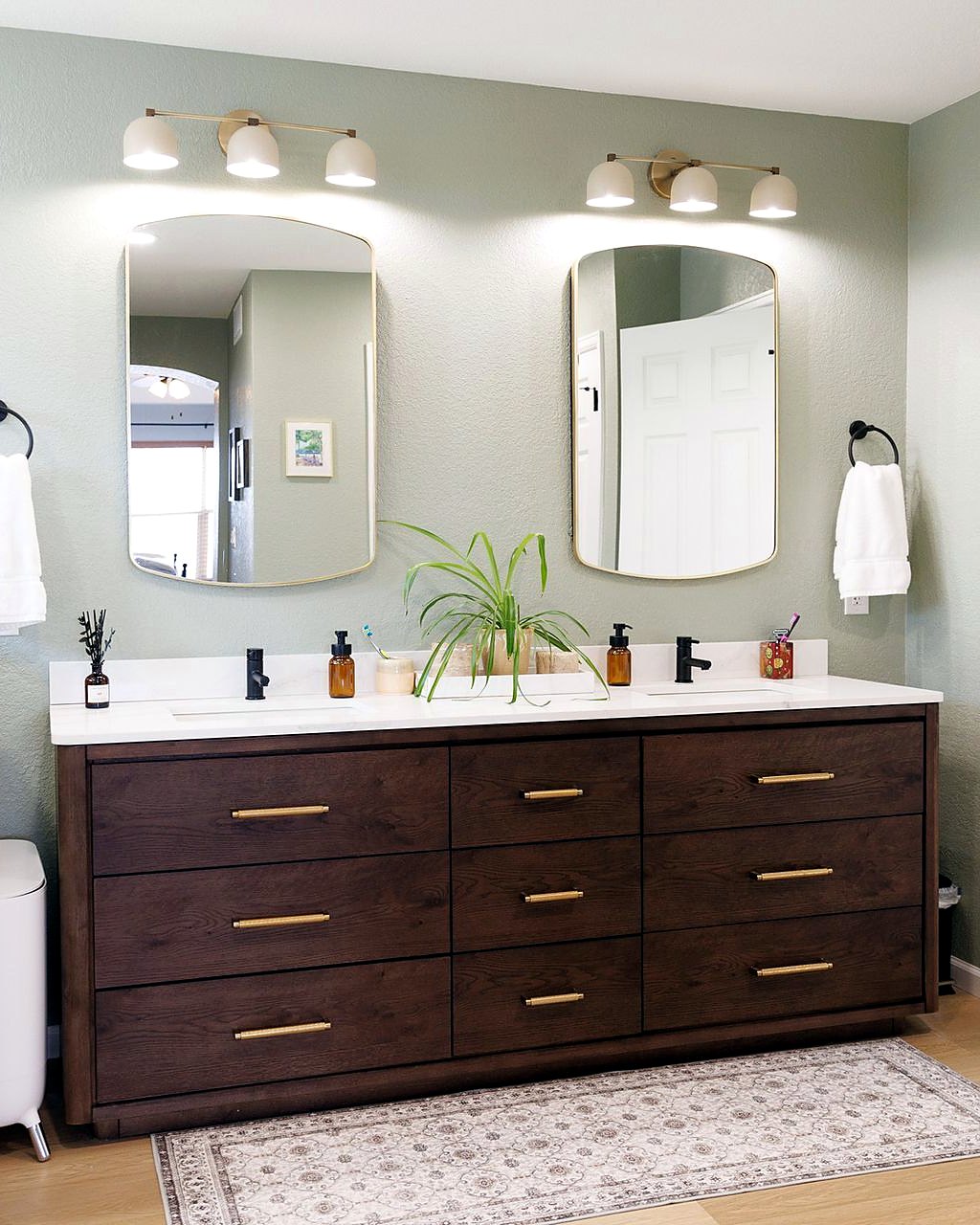 Bathroom with a dark wood double vanity, two mirrors and a white countertop